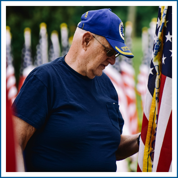 A U.S. veteran by an American flag.